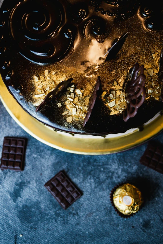 an elaborately decorated cake is surrounded by chocolate pieces