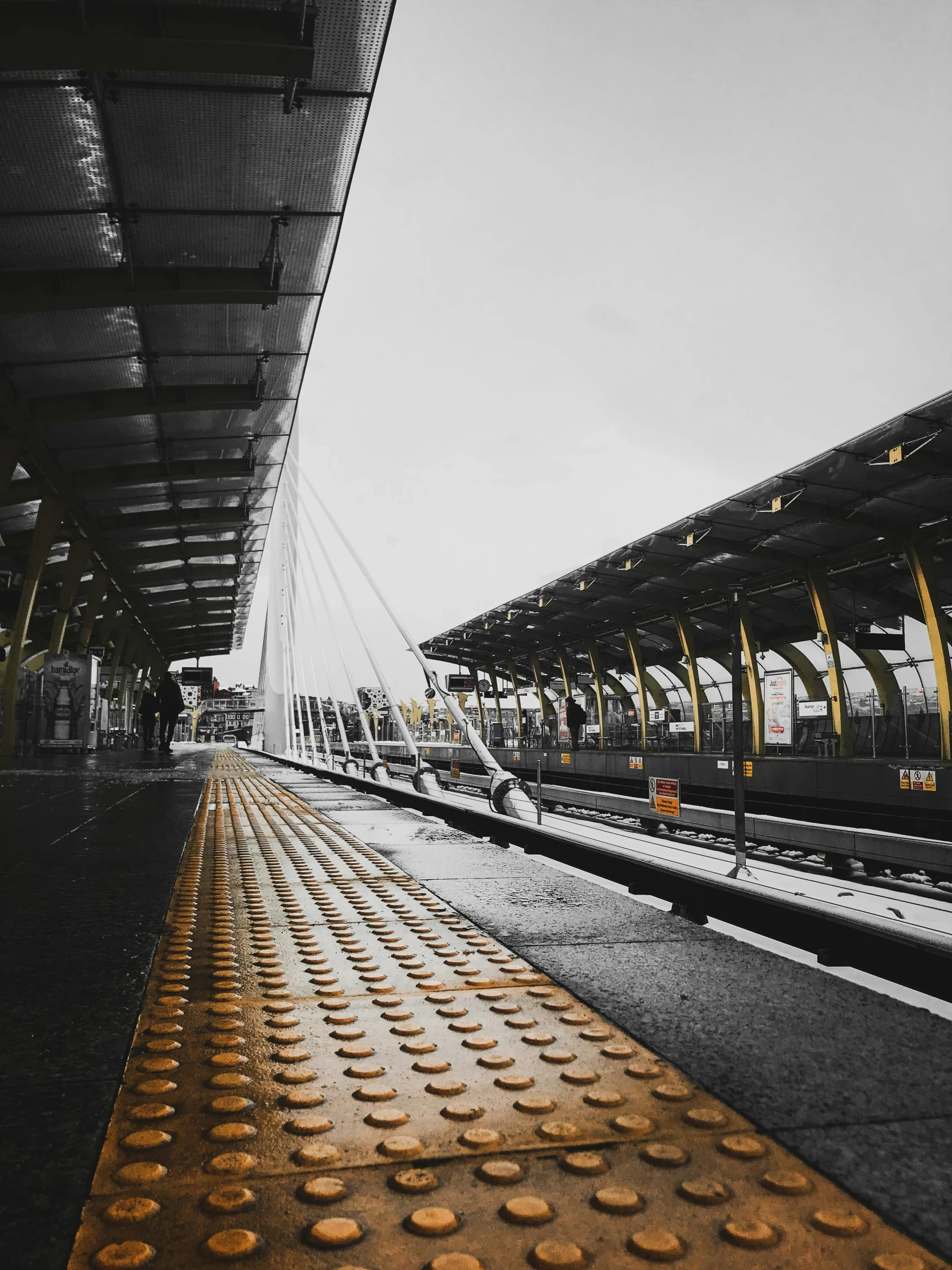 a train station with people walking by and it is raining