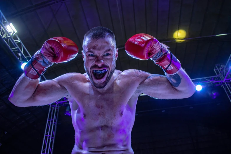 the shirtless fighter is ready to fight with his red gloves