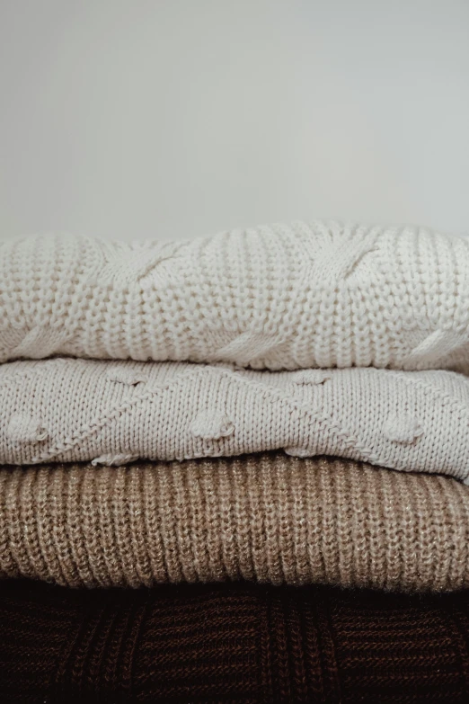 three warm sweaters stacked together, one on the other