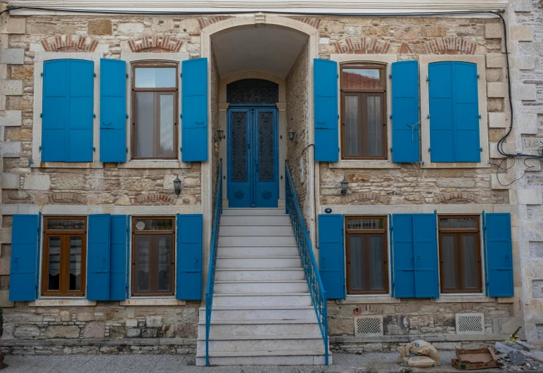 an old building with blue shutters and windows