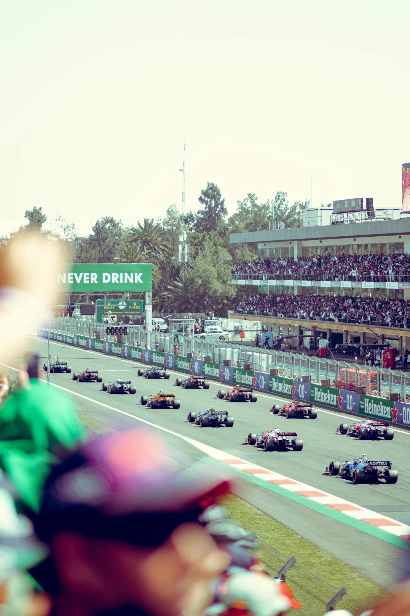 a line of racing cars during a race with the crowd behind