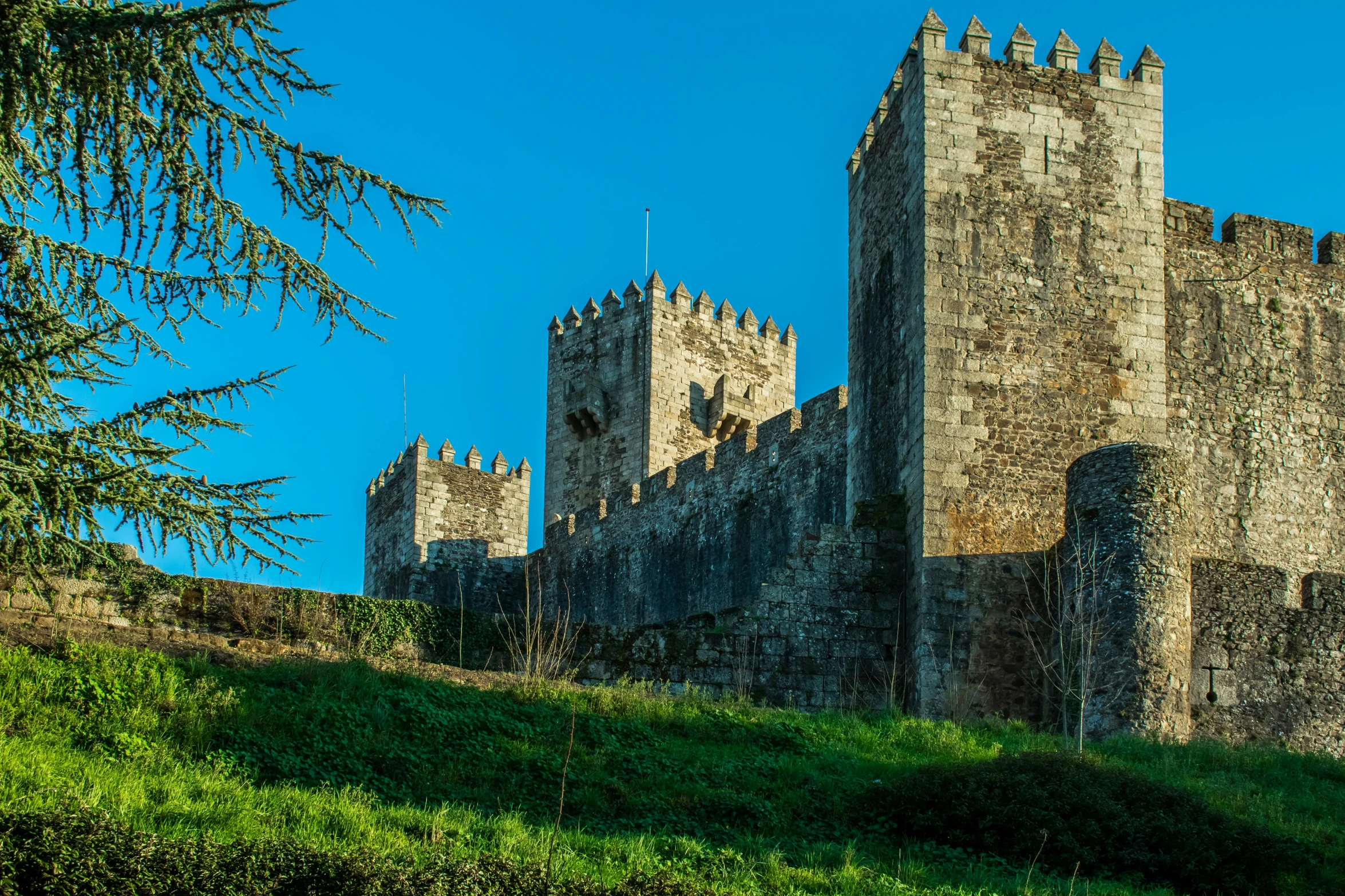 an old castle sitting on top of a lush green hillside