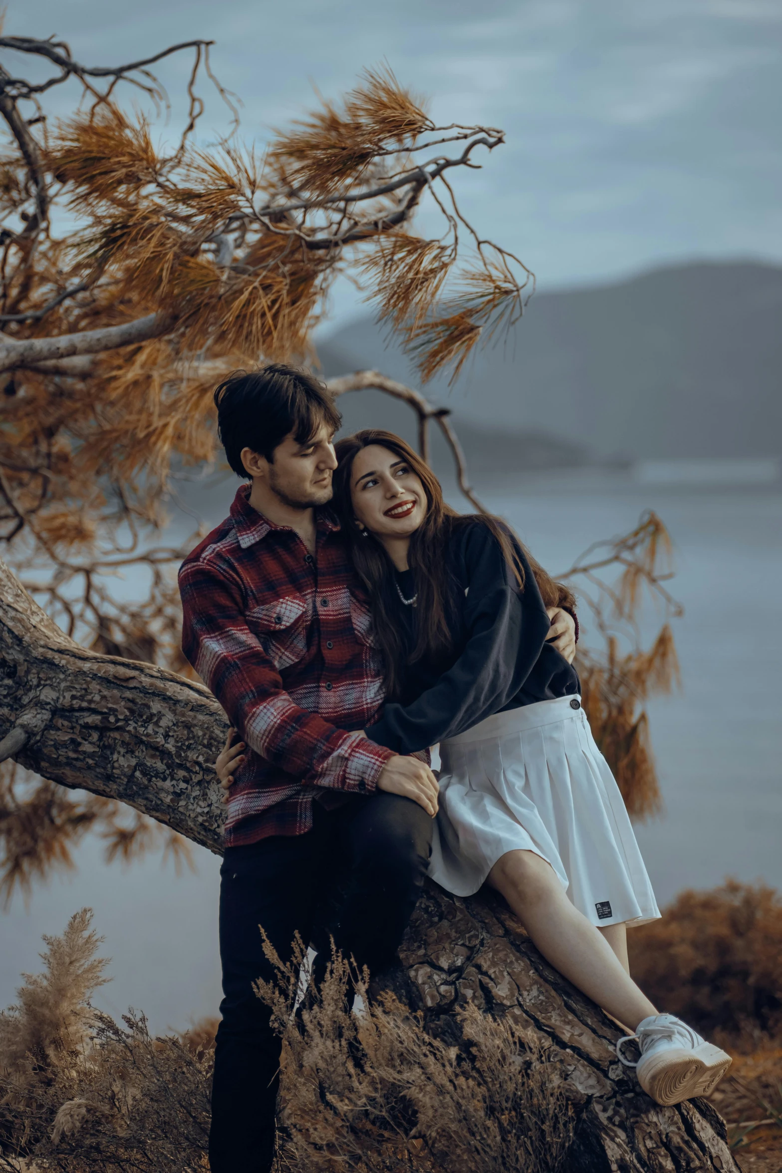 a young couple sits together while holding each other