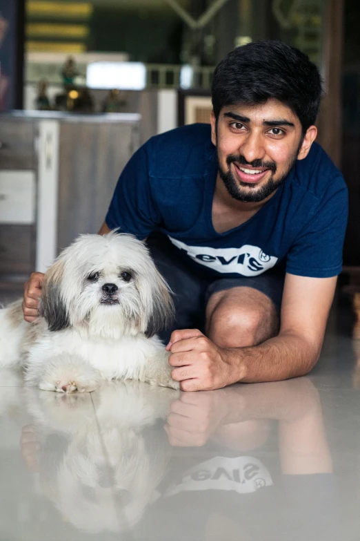 a man sitting on the ground next to his dog