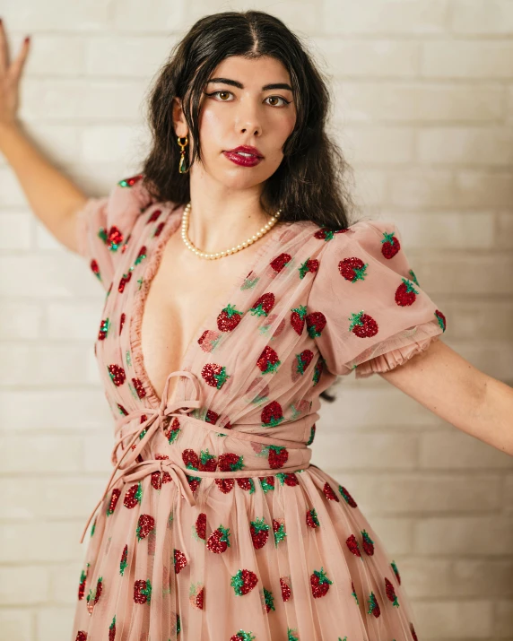 a woman with long dark hair wearing a dress with flowers on it