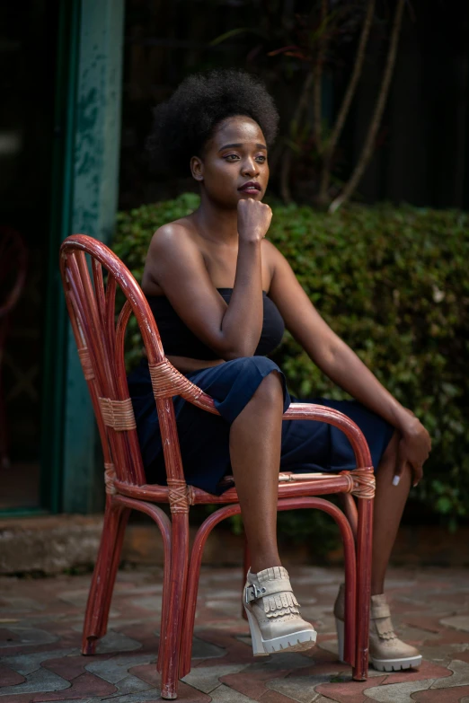 a woman sitting in a chair with her hand resting her chin