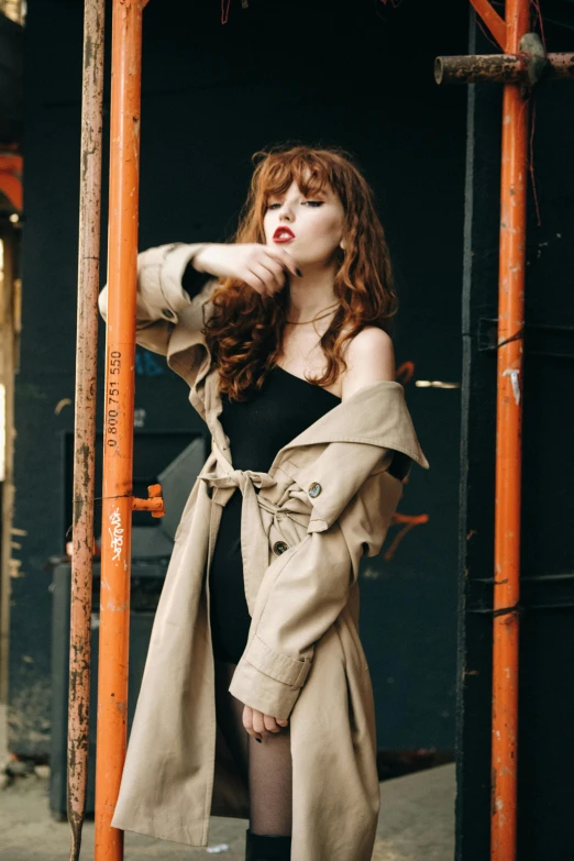 a young woman dressed as a buxom leaning on an orange pole