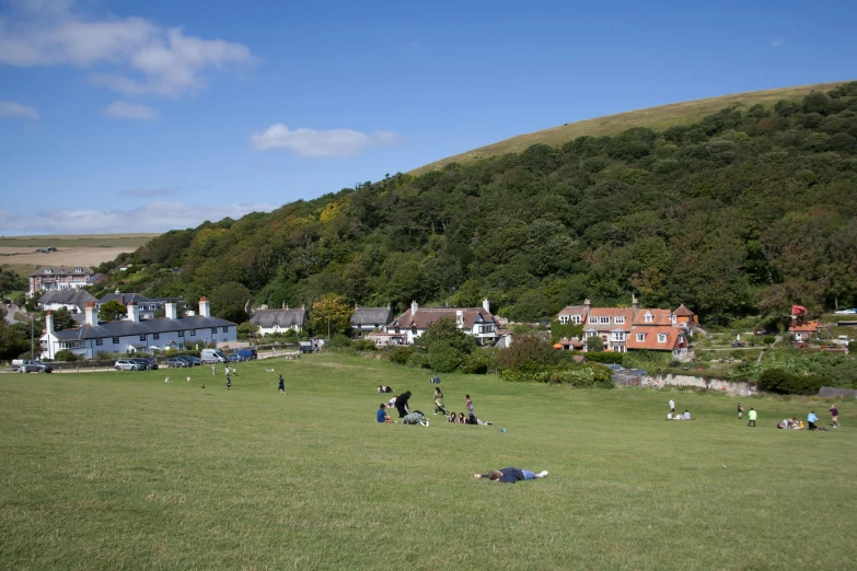 many people are gathered in a grassy field