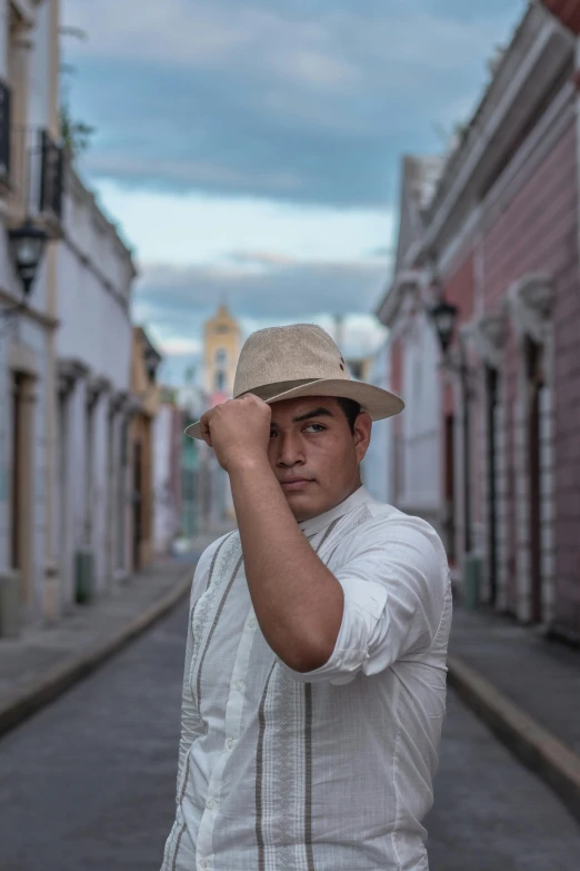 a man in a hat standing in a street