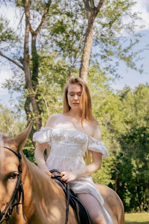 girl in white dress on horse outdoors near trees