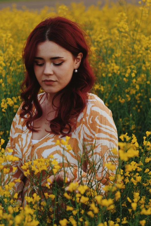 a woman is standing in a field of flowers