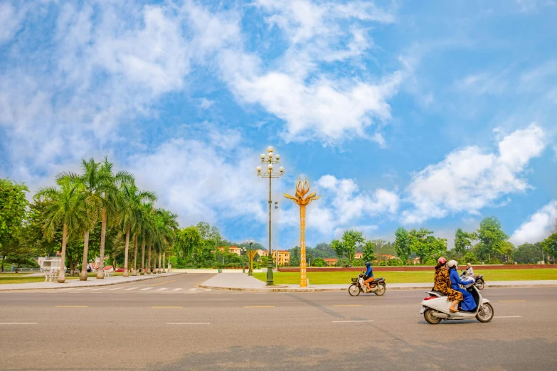 two people ride on scooters in the street