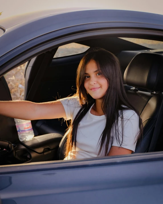 a pretty young lady in a blue car