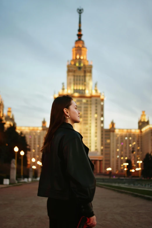 the woman is standing outside looking at the building