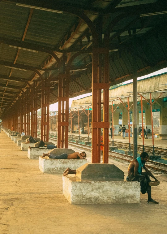 several men are walking in an empty train station