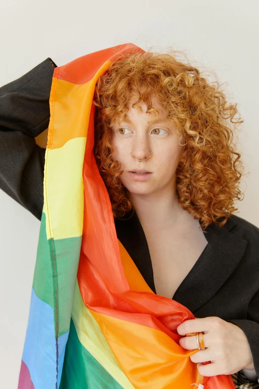 a young redhead woman is covering herself with a colorful scarf