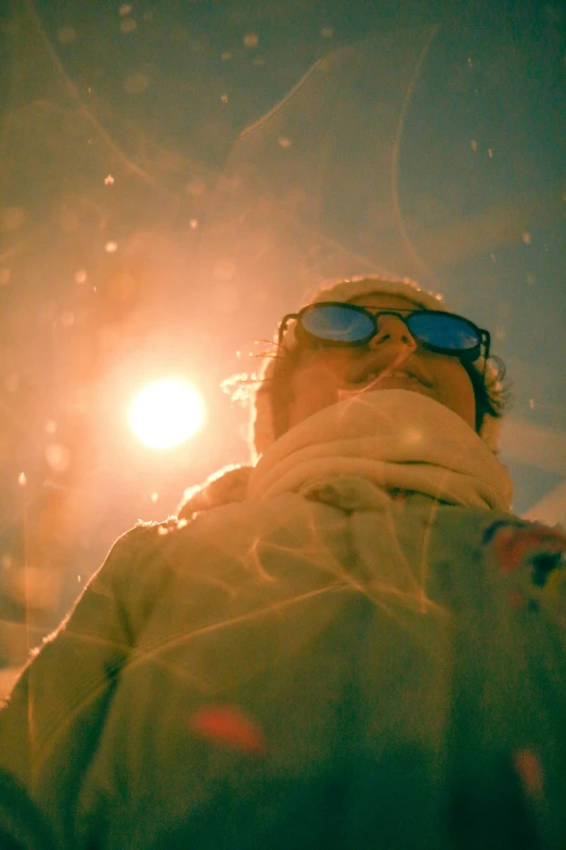 a man wearing sunglasses while standing by the street light