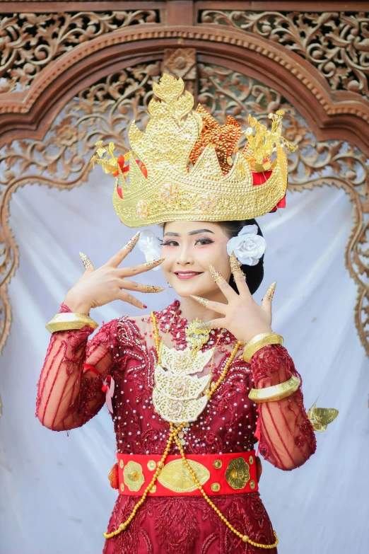 a beautiful thai woman dressed in red posing for a picture