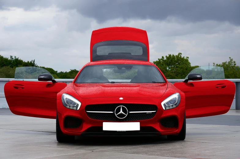 the hood of a red car on display at an auto show