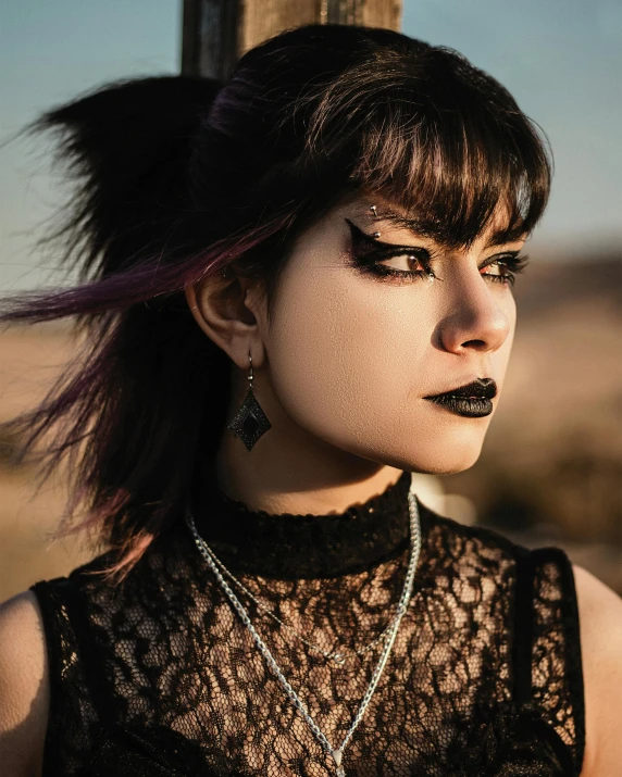 woman wearing black and silver makeup looking to her left