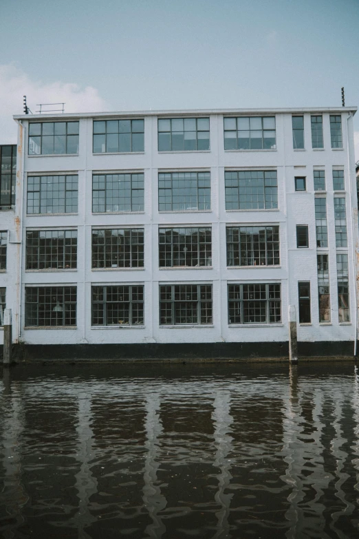 the outside of a white building in front of flooded water