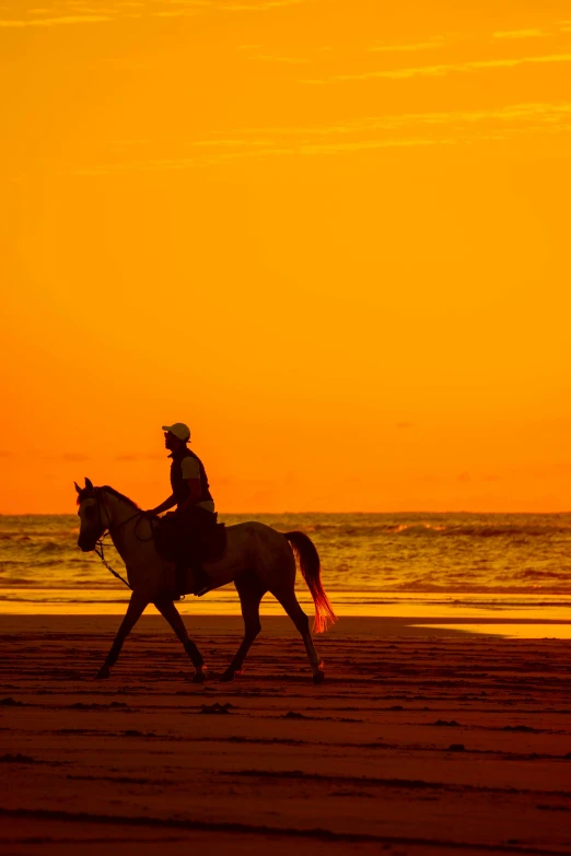 a man is riding a horse on the beach