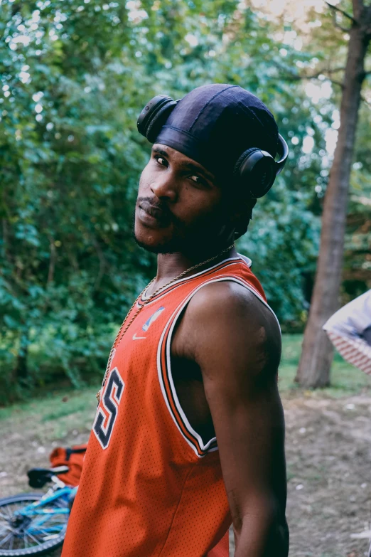 the basketball player is wearing headphones and has an orange jersey