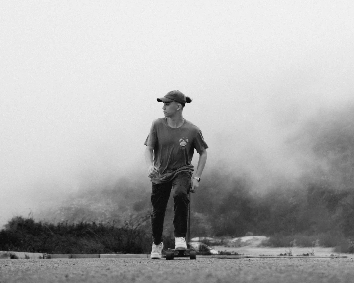 a man riding a skateboard down a road next to trees