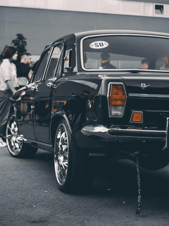 old car with passengers waiting in the background