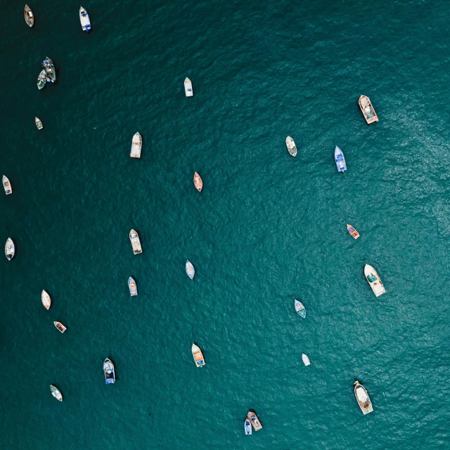 many boats float across the water, top down view