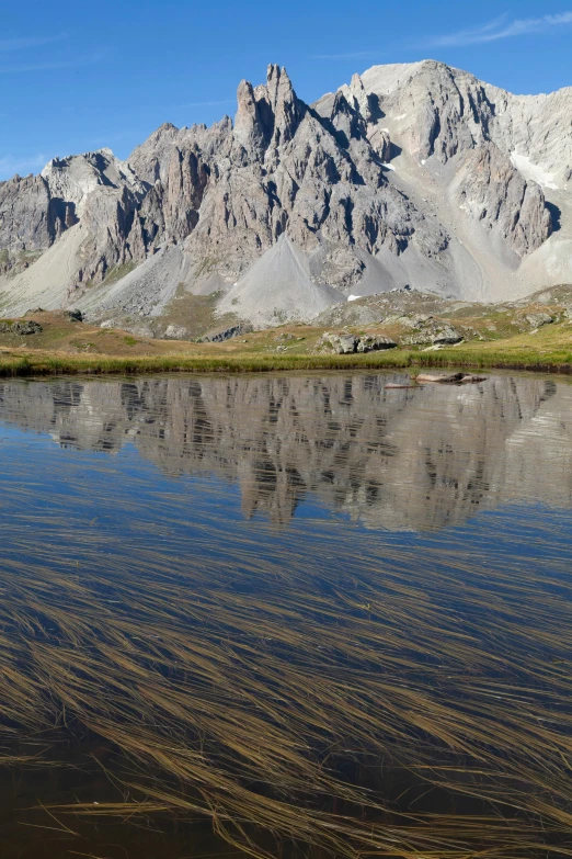 a mountain is behind the water with ripples in the water