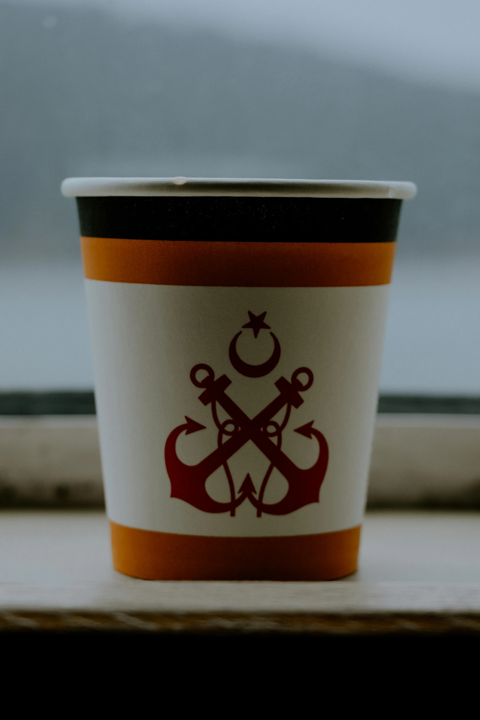 a coffee cup sitting on top of a window sill