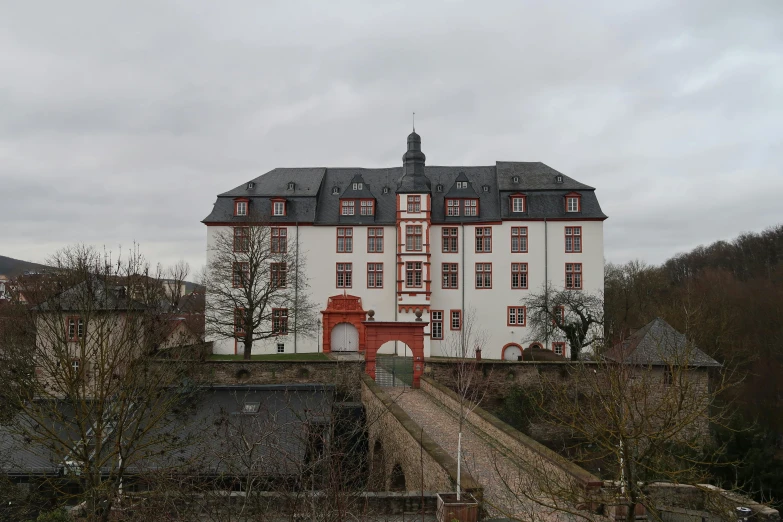 an old building on a small hill with lots of windows