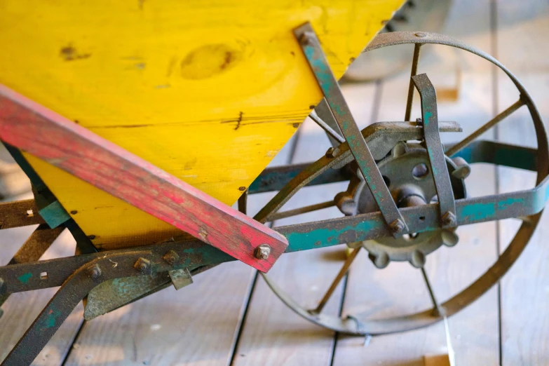 an old wheel with a wooden deck and yellow plastic wheel