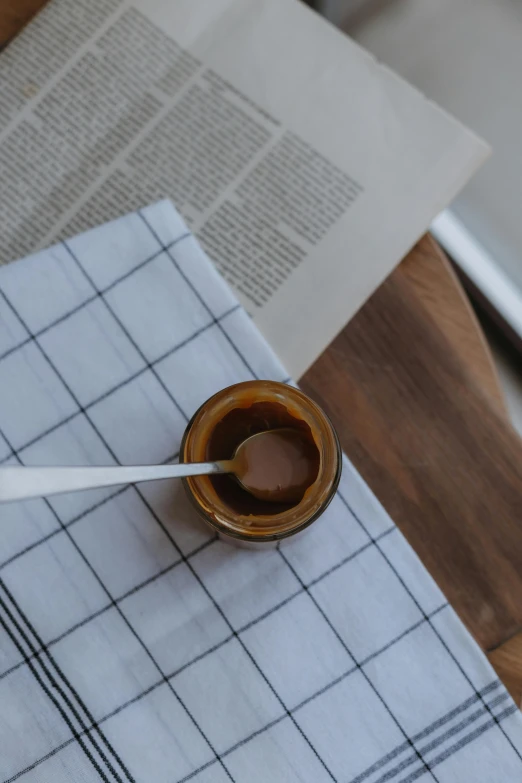 a small cup of brown liquid on a white napkin