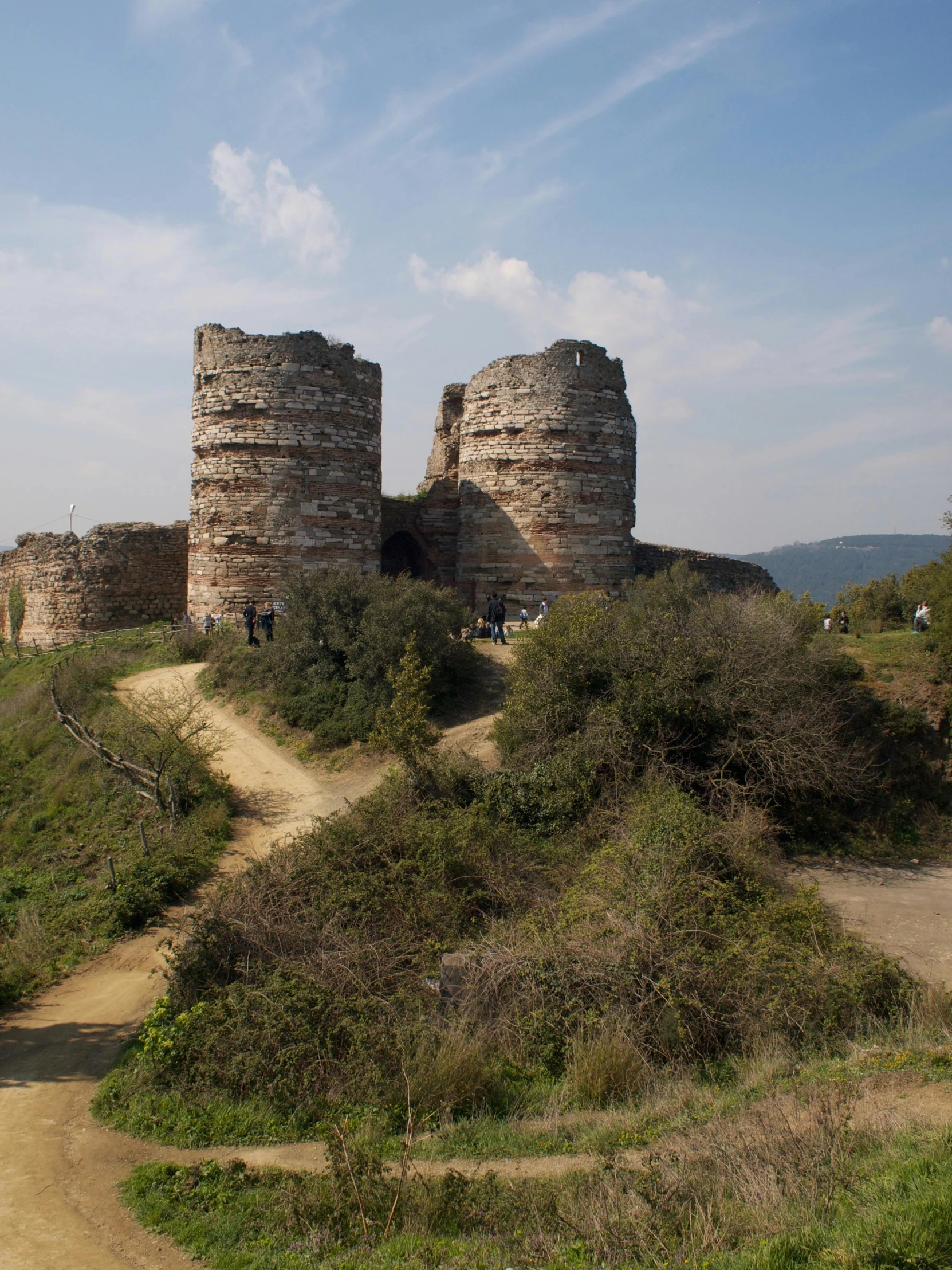 several brick structures on a hill side by trees