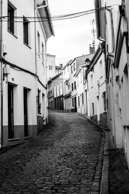 an alley with a brick road in between two buildings