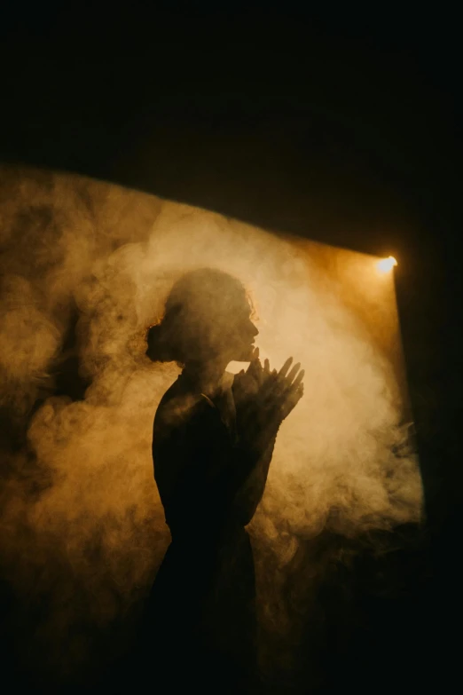 a person praying in a foggy area