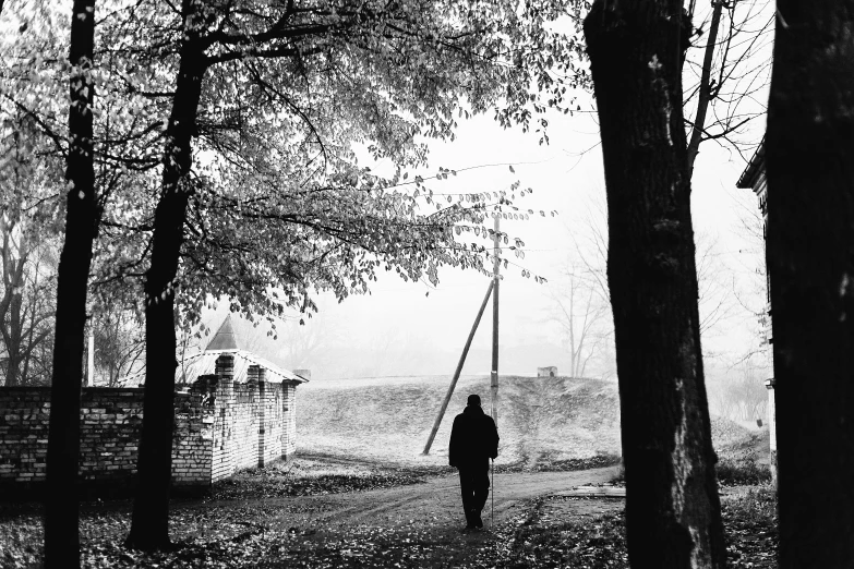 black and white image of a woman walking in a park