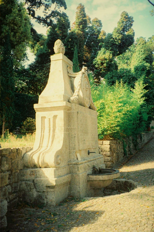 an old stone monument is sitting in the middle of a field