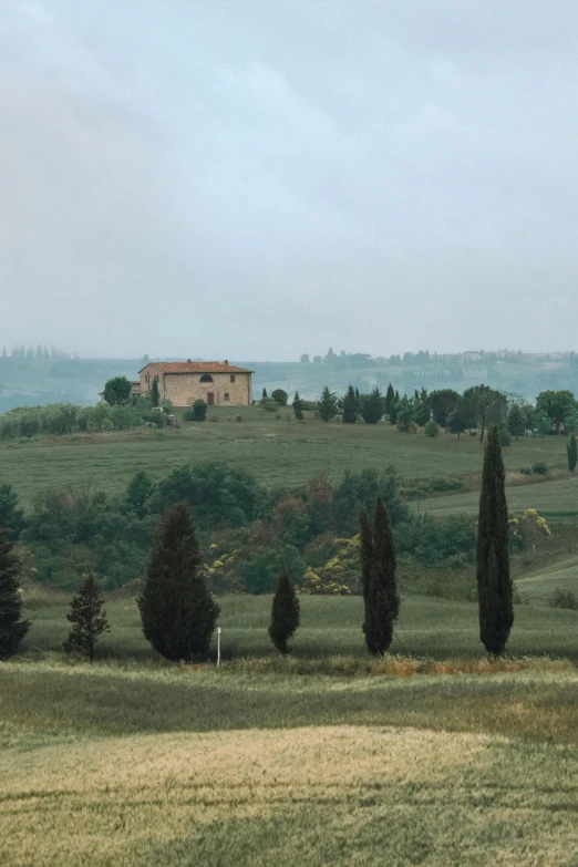 there is a house on the top of a hill in a field