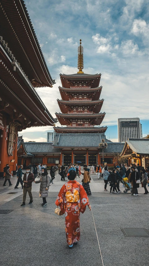 a woman with traditional dress walking through a large city