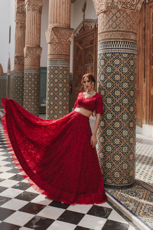 a woman in a long red dress posing for a po