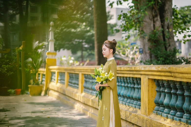 woman in traditional dress standing with flowers on her shoulder