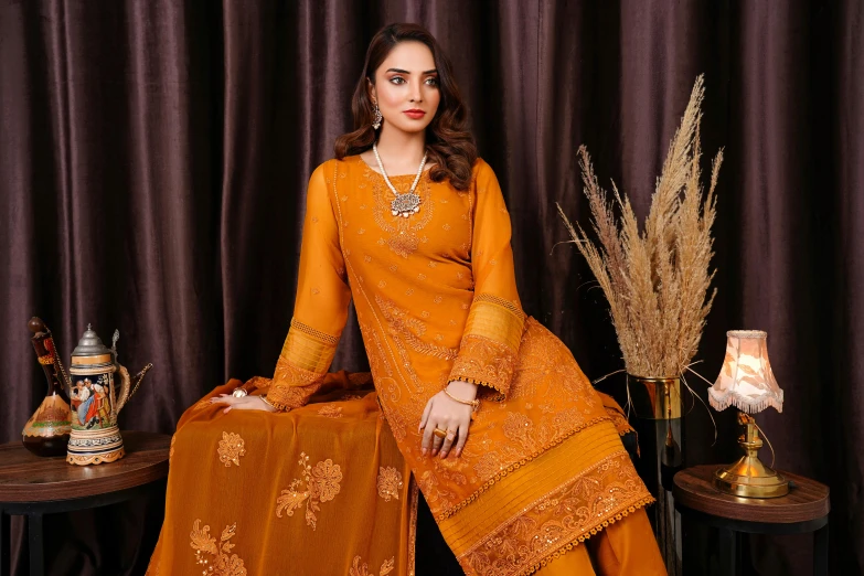 a woman sitting down wearing an orange colored outfit