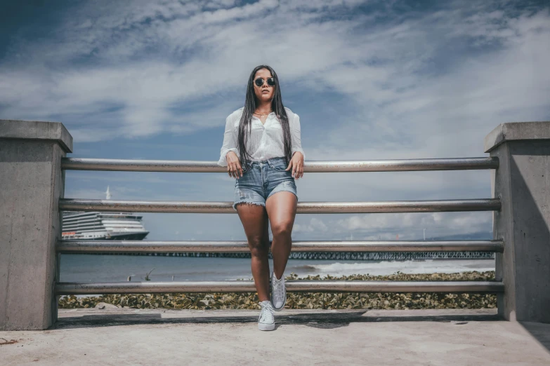 a woman standing on a rail wearing denim shorts