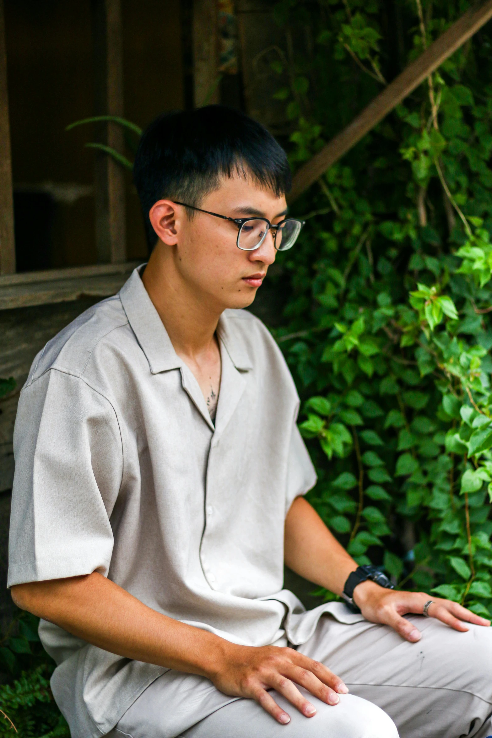 a man is sitting down wearing glasses