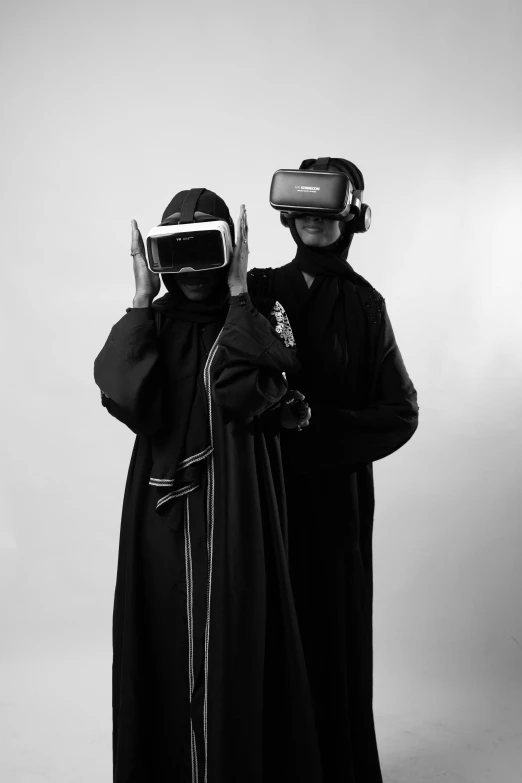 two people are dressed in black, one holding a head lamp