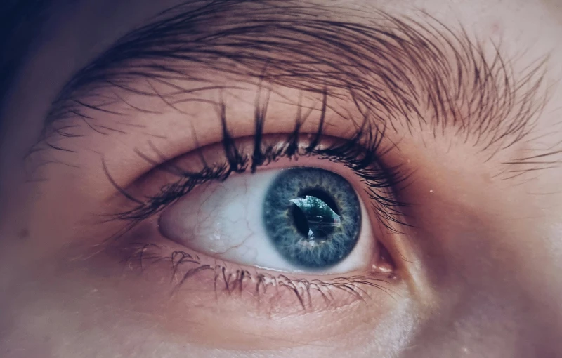 a close up image of an eye with light blue eyeshade